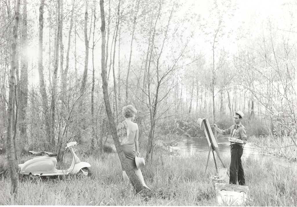 1960 a painter painting a man and Lambretta scooter in the forrest